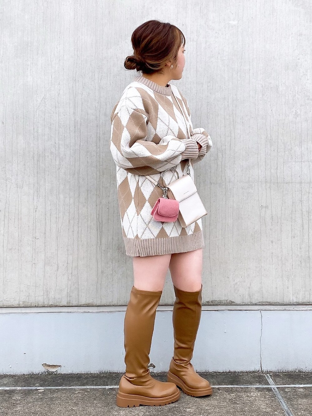 ベージュ系のニット/セーター、ピンク系のショルダーバッグ、イエロー系のブーツを着用したレディースの冬コーディネートの3枚目の写真