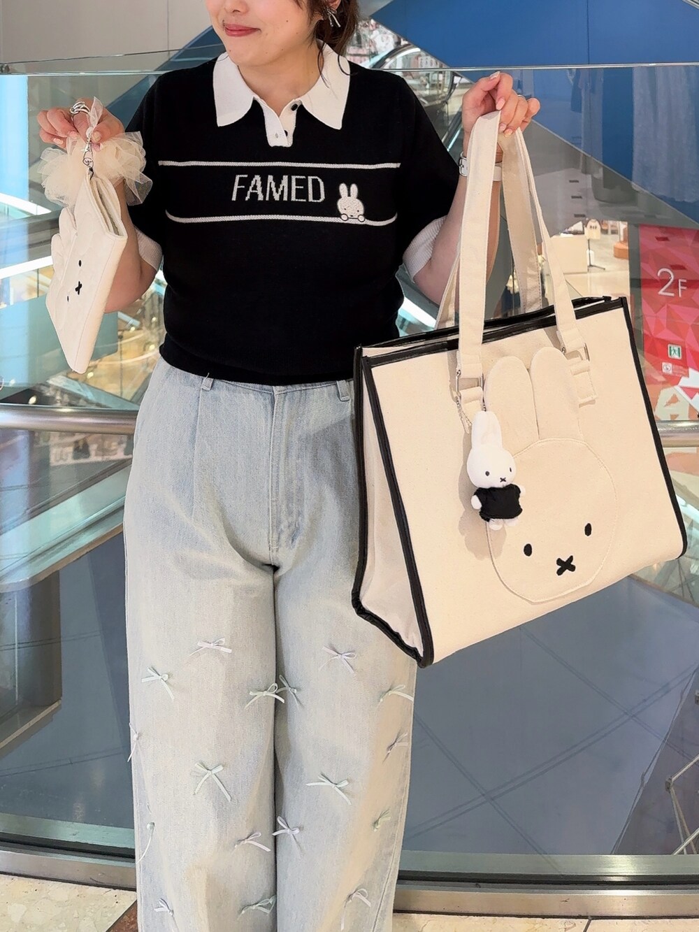 ベージュ系のトートバッグ、ブラック系のニット/セーター、ブルー系のその他パンツを着用したレディースの夏コーディネートの2枚目の写真