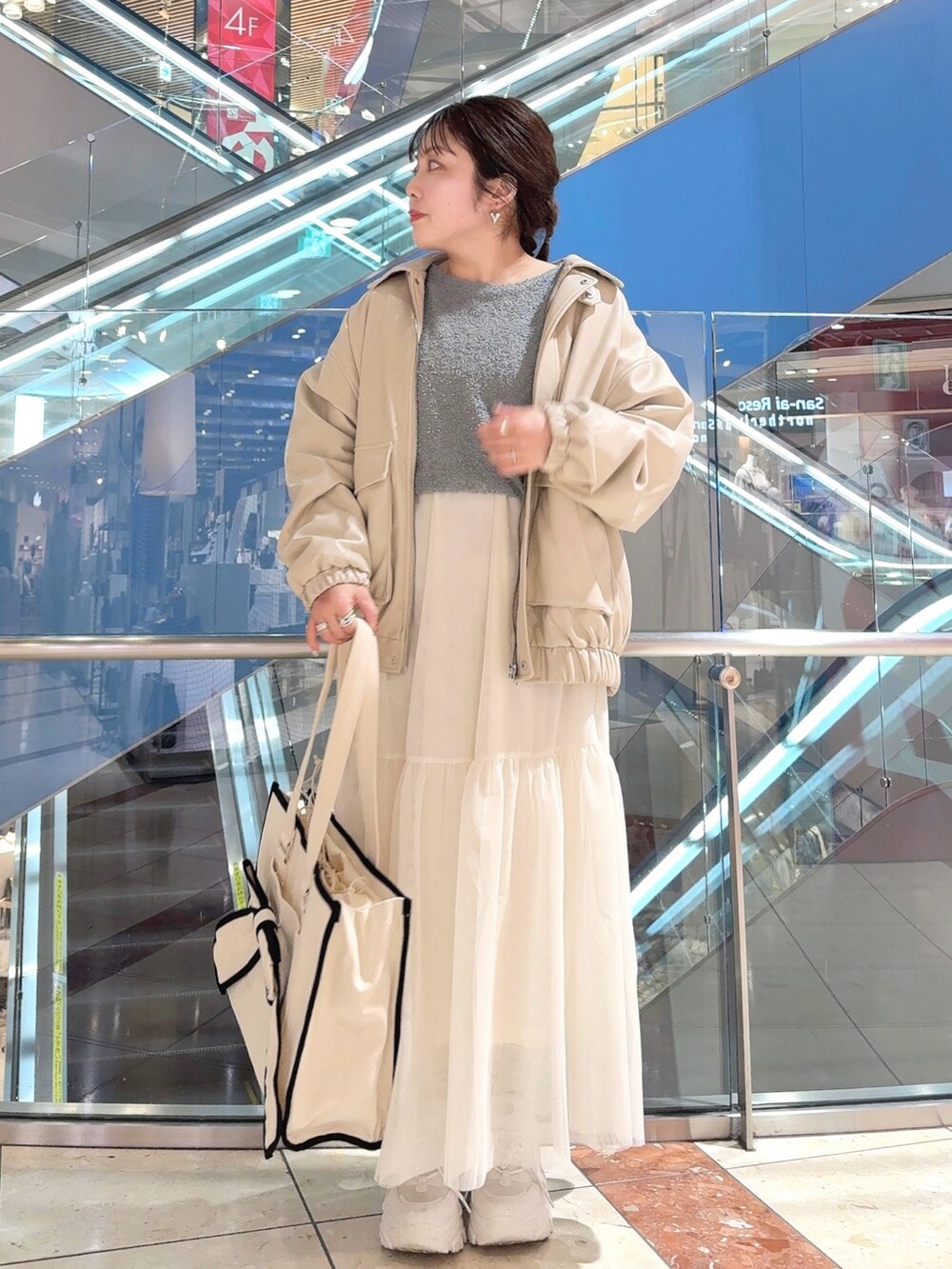 ホワイト系のブルゾン、ブルー系のワンピース、ホワイト系のトートバッグを着用したレディースの冬コーディネートの2枚目の写真