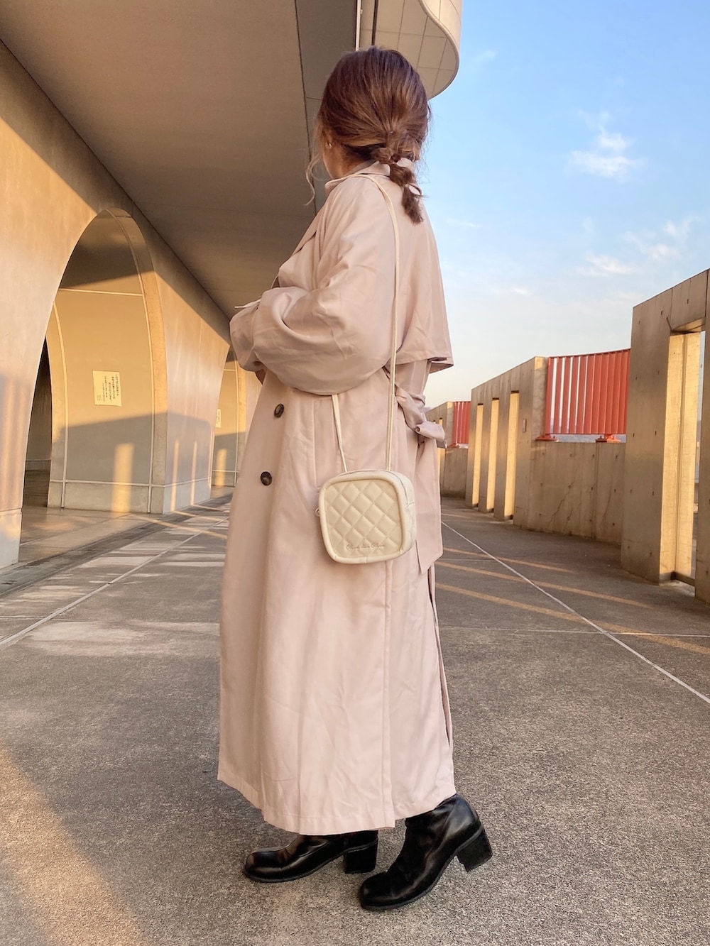 ベージュ系のトレンチコート、ホワイト系のスウェット、ブルー系のTシャツ/カットソーを着用したレディースの冬コーディネートの2枚目の写真