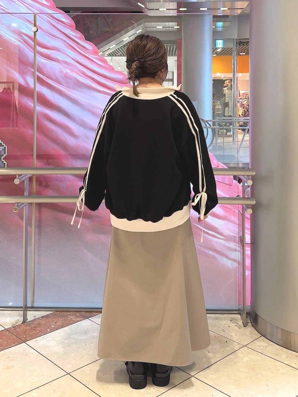 ブラック系のジャージ、ベージュ系のワンピース、ブラック系のブーツを着用したレディースの夏コーディネートの3枚目の写真