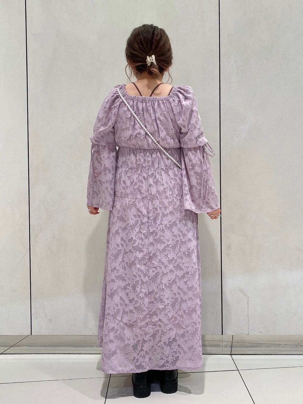 パープル系のワンピース、ブラック系のブーツ、ピンク系のその他雑貨を着用したレディースの冬コーディネートの3枚目の写真