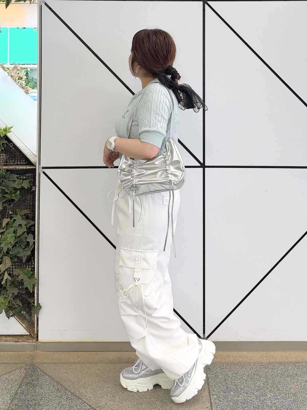 ブルー系のニット/セーター、ホワイト系のカーゴパンツ、シルバー系のショルダーバッグを着用したレディースの夏コーディネートの2枚目の写真