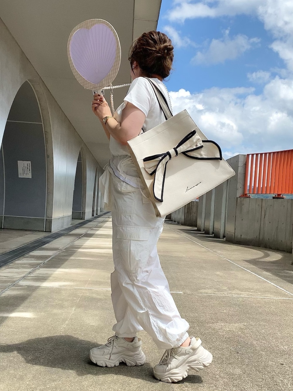 ホワイト系のTシャツ/カットソー、ホワイト系のつなぎ/オールインワン、ブラック系のトートバッグを着用したレディースの夏コーディネートの3枚目の写真