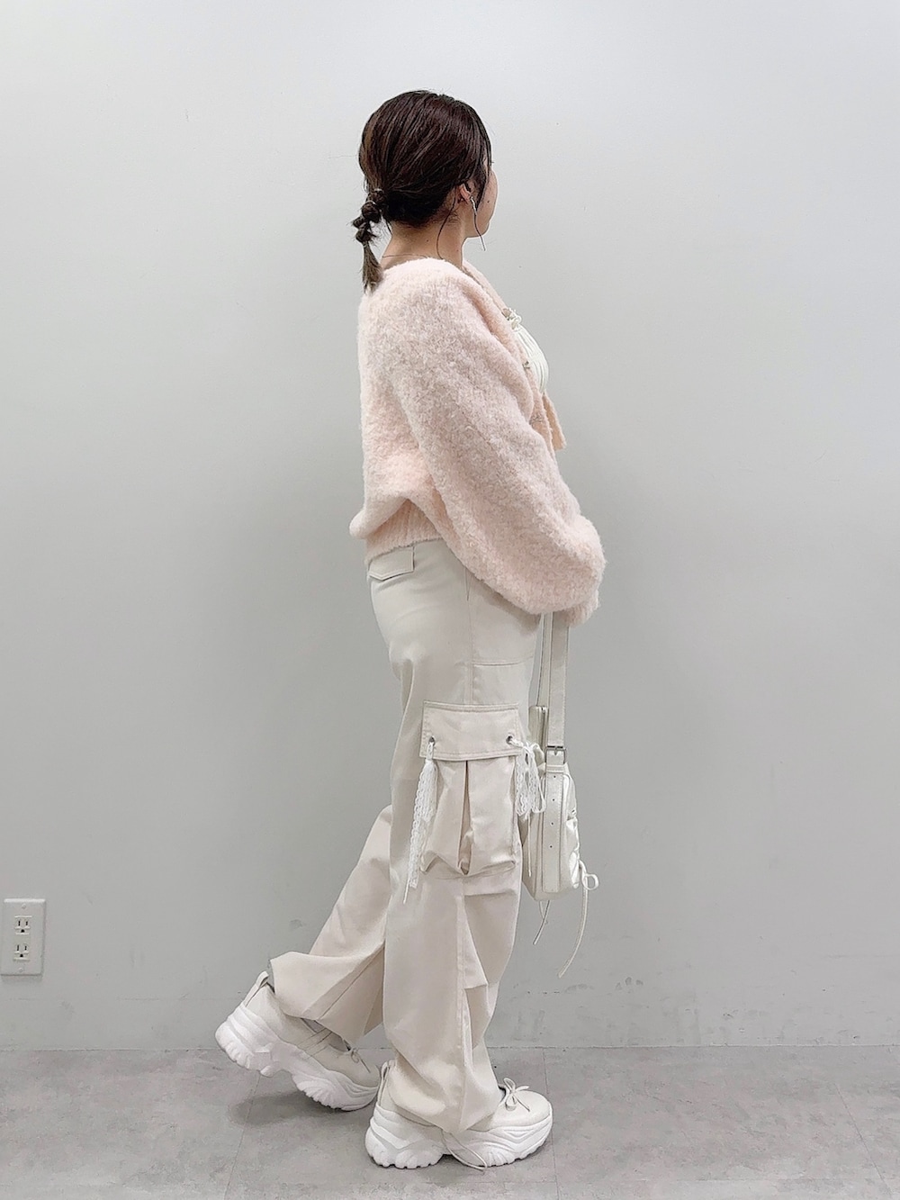 ピンク系のカーディガン/ボレロ、ホワイト系のキャミソール、ホワイト系のショルダーバッグを着用したレディースの夏コーディネートの3枚目の写真