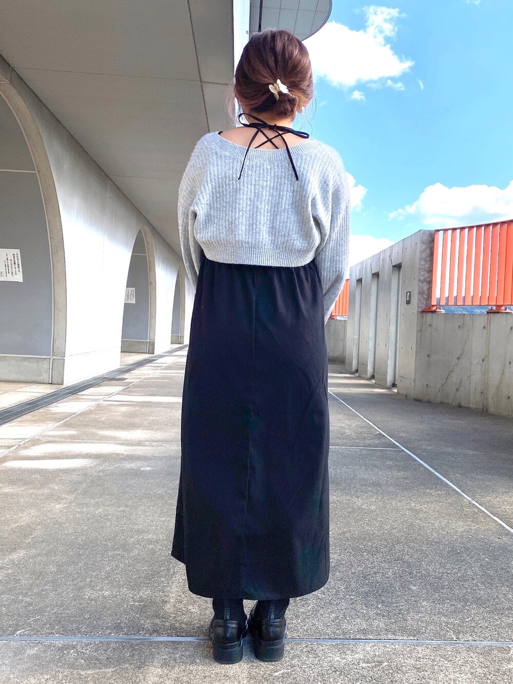 ブラック系のワンピース、ブラック系のショルダーバッグ、ブラック系のブーツを着用したレディースの冬コーディネートの4枚目の写真