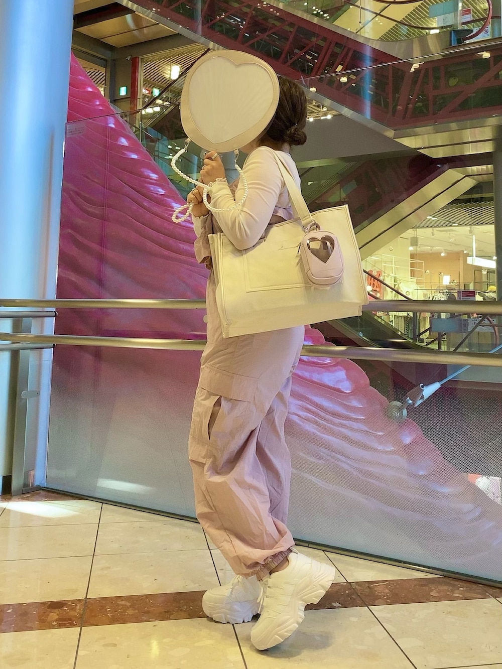 ピンク系のつなぎ/オールインワン、ピンク系のトートバッグ、ホワイト系のスニーカーを着用したレディースの秋コーディネートの3枚目の写真