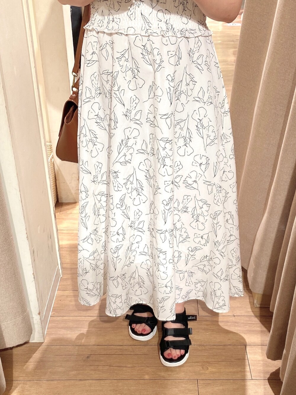 ホワイト系のワンピース、ブラック系のサンダル、イエロー系のショルダーバッグを着用したレディースの春コーディネートの4枚目の写真