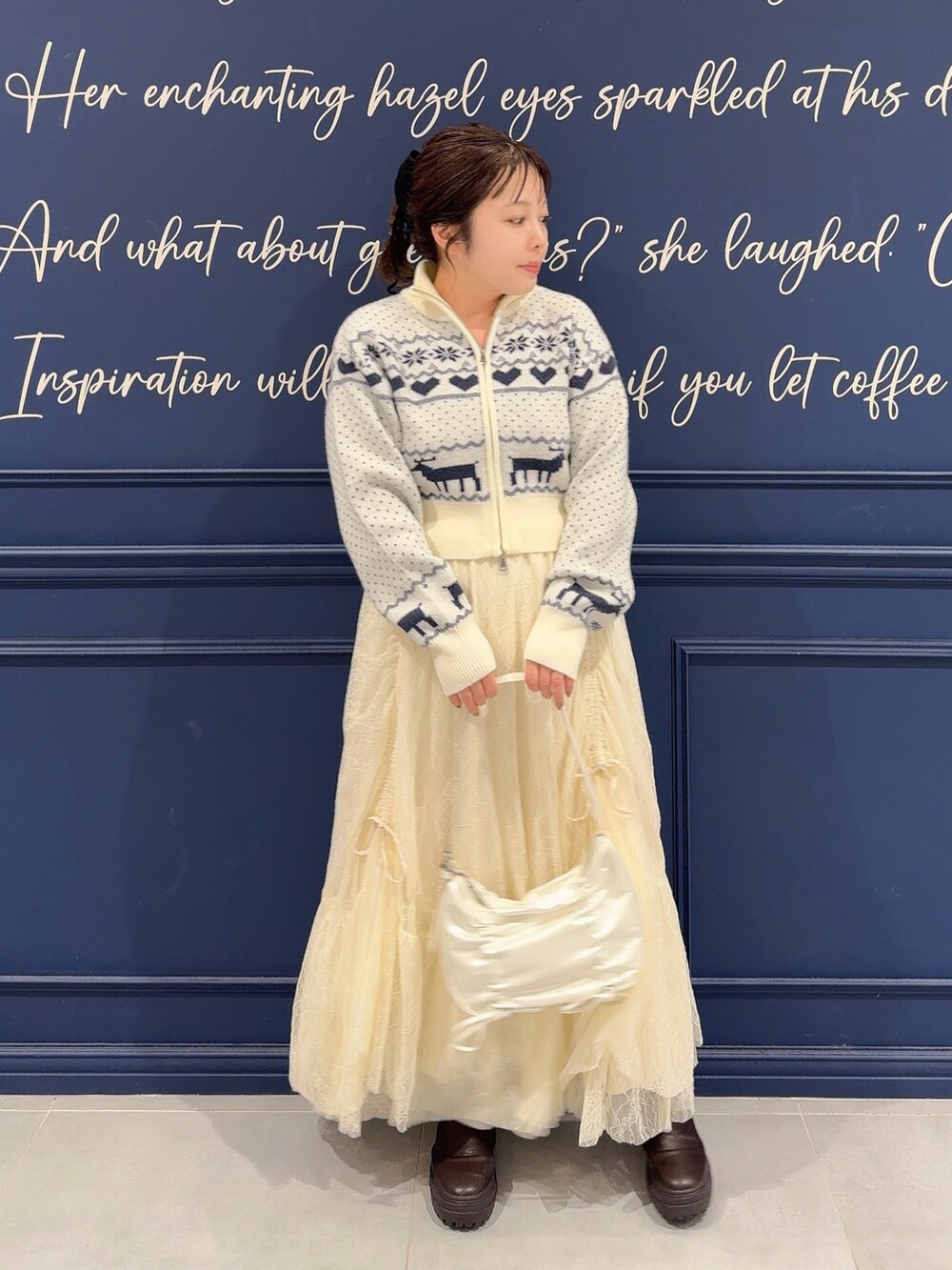 ホワイト系のカーディガン/ボレロ、ホワイト系のスカート、ブラウン系のブーツを着用したレディースの秋コーディネートの2枚目の写真