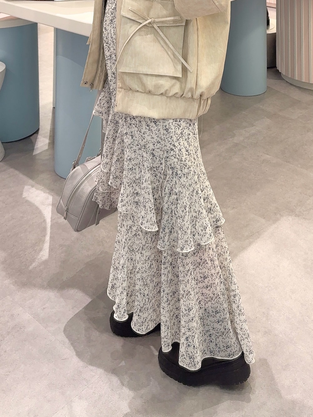 ホワイト系のブルゾン、ホワイト系のワンピース、ブルー系のショルダーバッグを着用したレディースの冬コーディネートの4枚目の写真