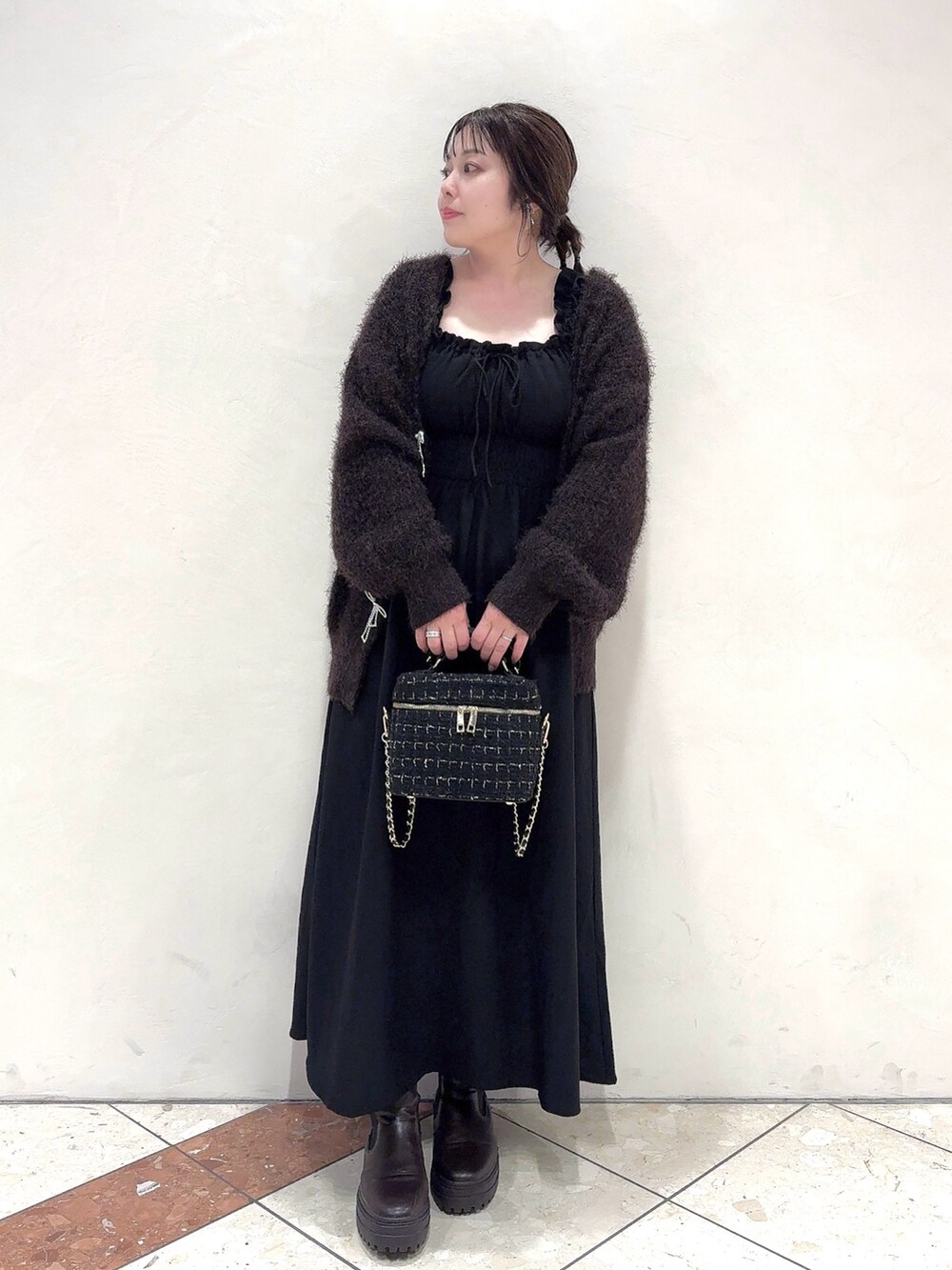 ブラウン系のカーディガン/ボレロ、ブラック系のワンピース、ブラック系のショルダーバッグを着用したレディースの秋コーディネートの2枚目の写真