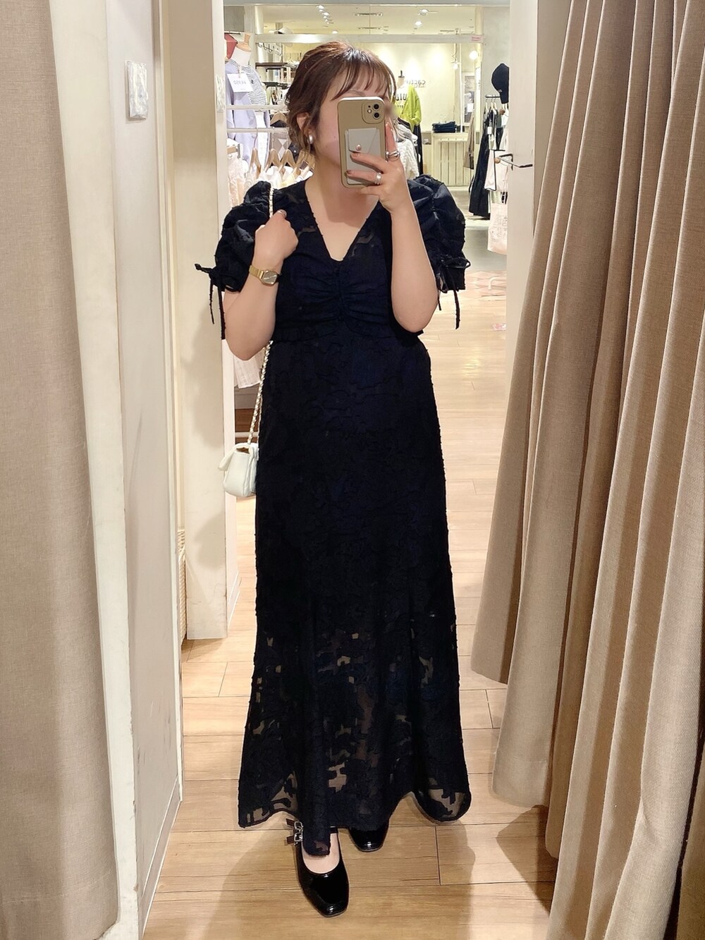 ブラック系のワンピース、ブラック系のパンプスを着用したレディースの春コーディネートの2枚目の写真