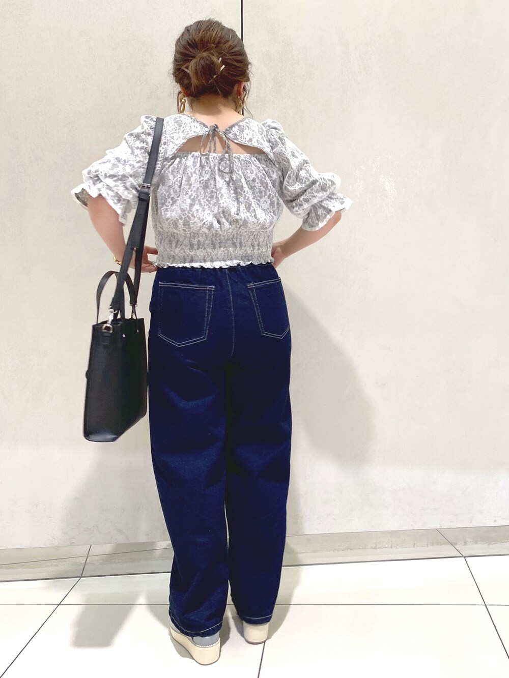 ブルー系のシャツ/ブラウス、ブラック系のショルダーバッグ、ブルー系のデニムパンツを着用したレディースの春コーディネートの3枚目の写真