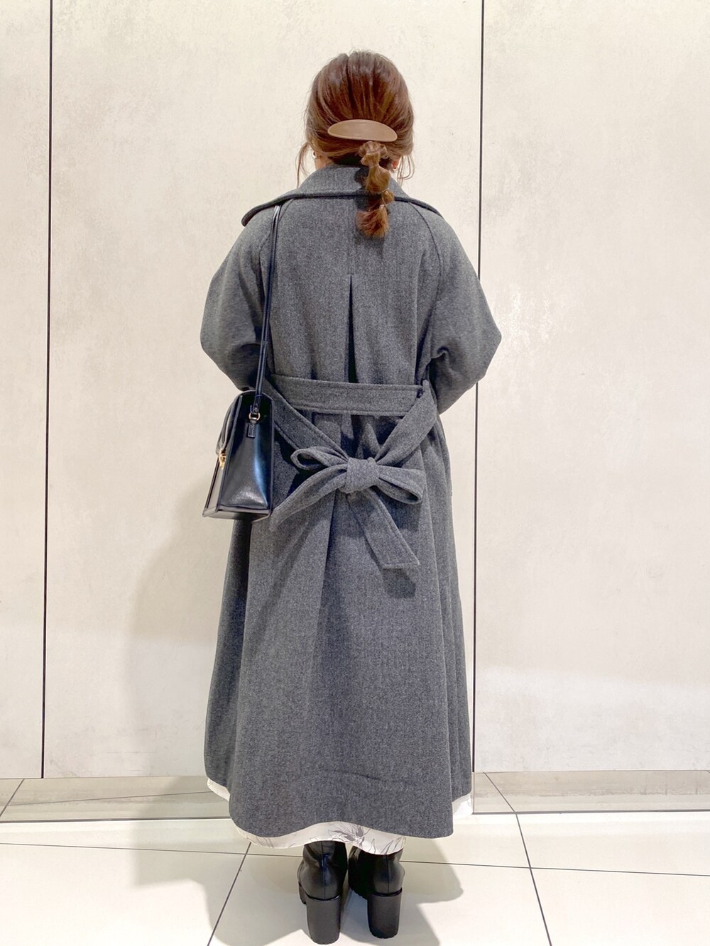 ホワイト系のワンピース、ブラック系のブーツ、ブラック系のショルダーバッグを着用したレディースの秋コーディネートの3枚目の写真