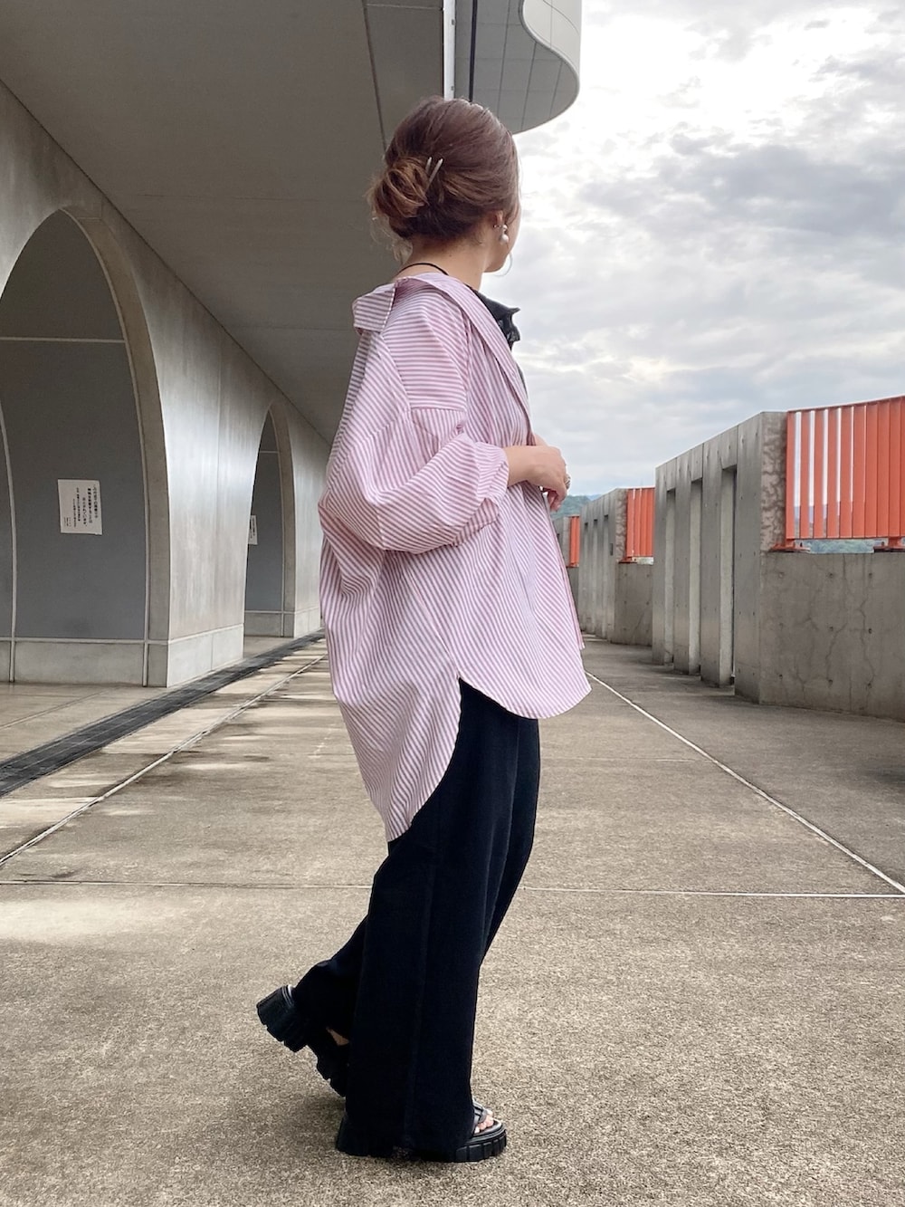 ピンク系のシャツ/ブラウス、ブラック系のサロペット/オーバーオール、ブラック系のサンダルを着用したレディースの夏コーディネートの2枚目の写真