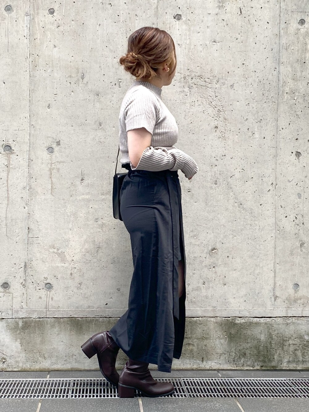 ブラック系のスカート、ブラウン系のブーツ、ブラウン系のニット/セーターを着用したレディースの夏コーディネートの2枚目の写真