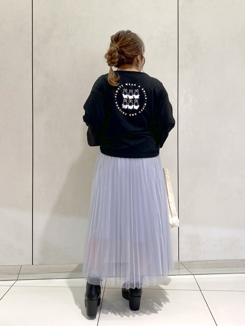 ブラック系のTシャツ/カットソー、ホワイト系のトートバッグ、ブラック系のブーツを着用したレディースの秋コーディネートの2枚目の写真