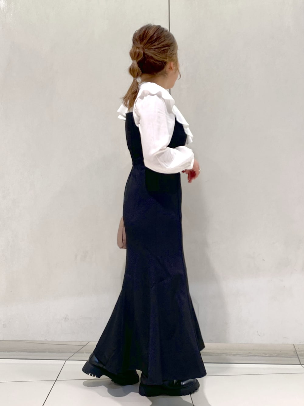 ブラック系のワンピース、ブラウン系のショルダーバッグ、ブラック系のブーツを着用したレディースの秋コーディネートの2枚目の写真