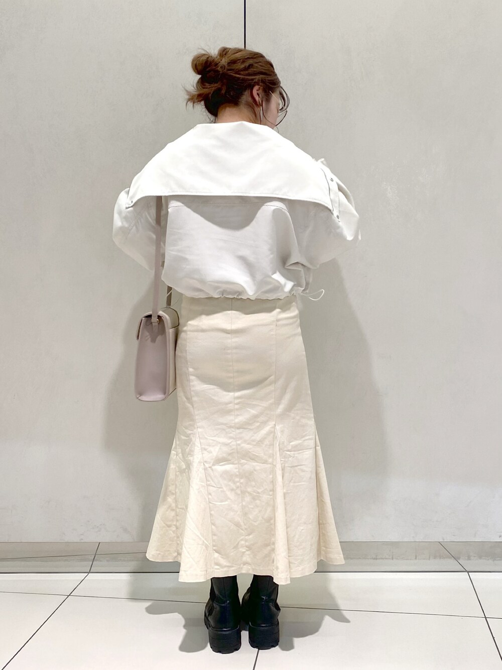 ホワイト系のブルゾン、ピンク系のTシャツ/カットソー、ホワイト系のスカートを着用したレディースの冬コーディネートの3枚目の写真