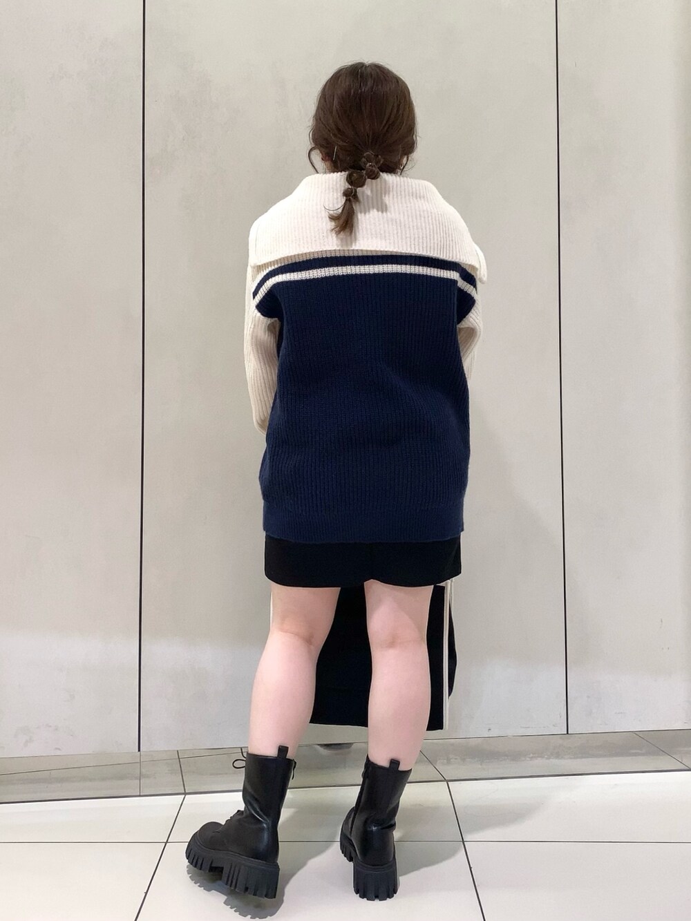 ブルー系のニット/セーター、ブラック系のスカート、ブラック系のトートバッグを着用したレディースの夏コーディネートの4枚目の写真