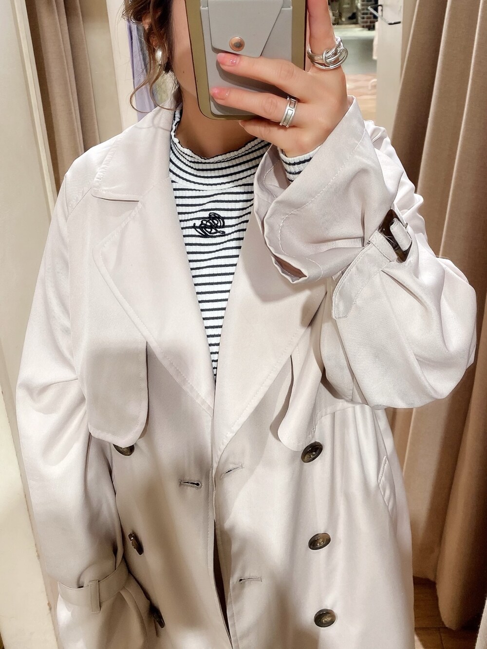 ベージュ系のトレンチコート、ホワイト系のTシャツ/カットソー、ホワイト系のカーゴパンツを着用したレディースの冬コーディネートの2枚目の写真