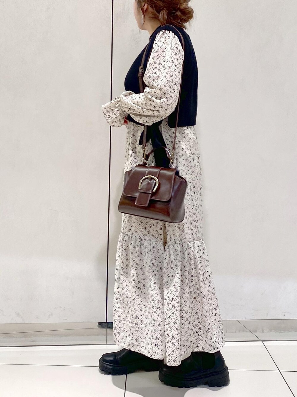 ブラック系のワンピース、ブラック系のブーツ、ブラウン系のショルダーバッグを着用したレディースの冬コーディネートの2枚目の写真