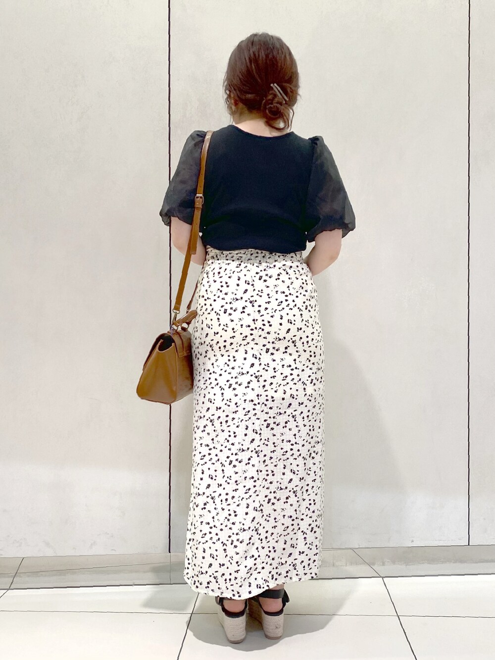 ブラック系のTシャツ/カットソー、ホワイト系のスカート、ブラック系のサンダルを着用したレディースの春コーディネートの3枚目の写真