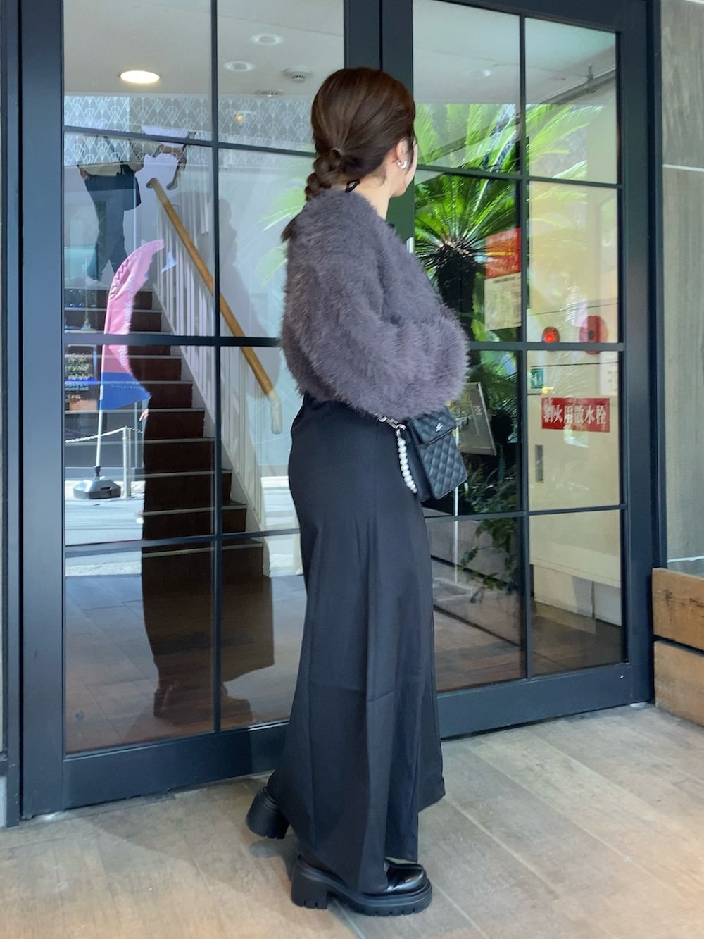 グレー系のワンピース、ブラック系のショルダーバッグ、ブラック系のブーツを着用したレディースの秋コーディネートの3枚目の写真