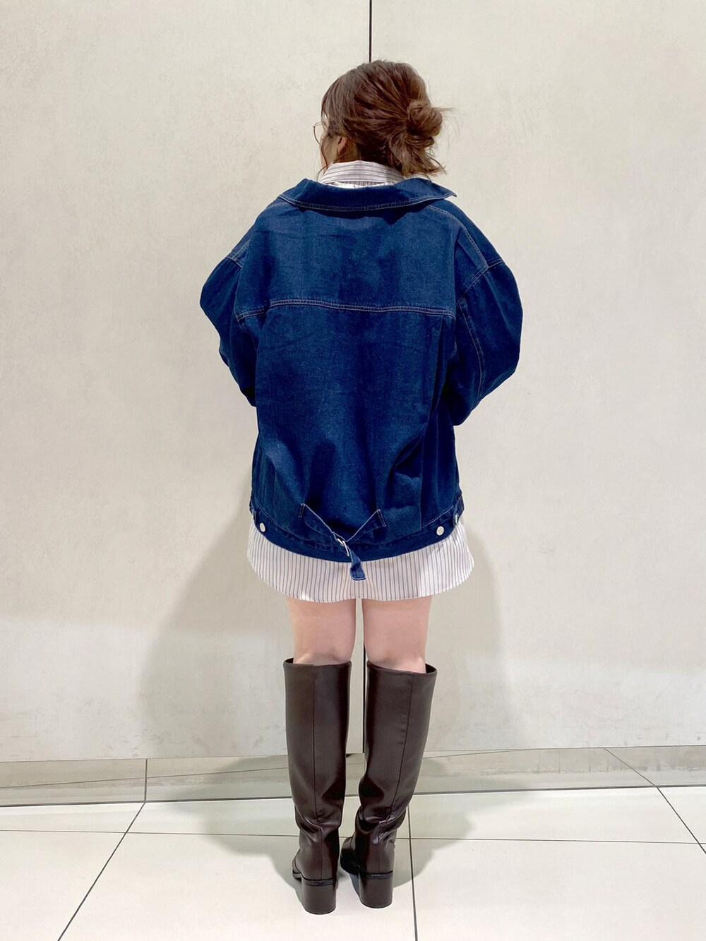 ブルー系のデニムジャケット、ホワイト系のTシャツ/カットソー、ブラウン系のブーツを着用したレディースの冬コーディネートの3枚目の写真