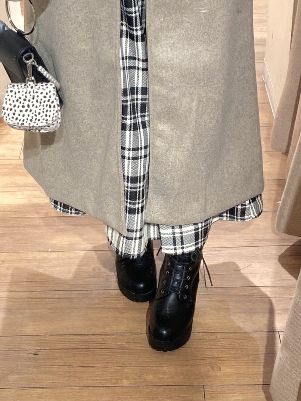 ブラウン系のステンカラーコート、ブラック系のニット/セーター、その他のスカートを着用したレディースの冬コーディネートの3枚目の写真