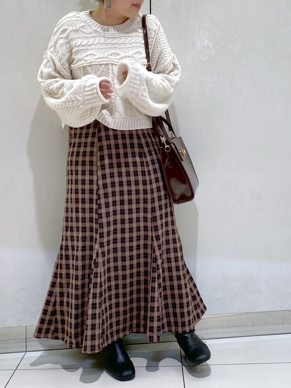 ホワイト系のニット/セーター、ブラウン系のスカート、ブラウン系のショルダーバッグを着用したレディースの秋コーディネートの2枚目の写真
