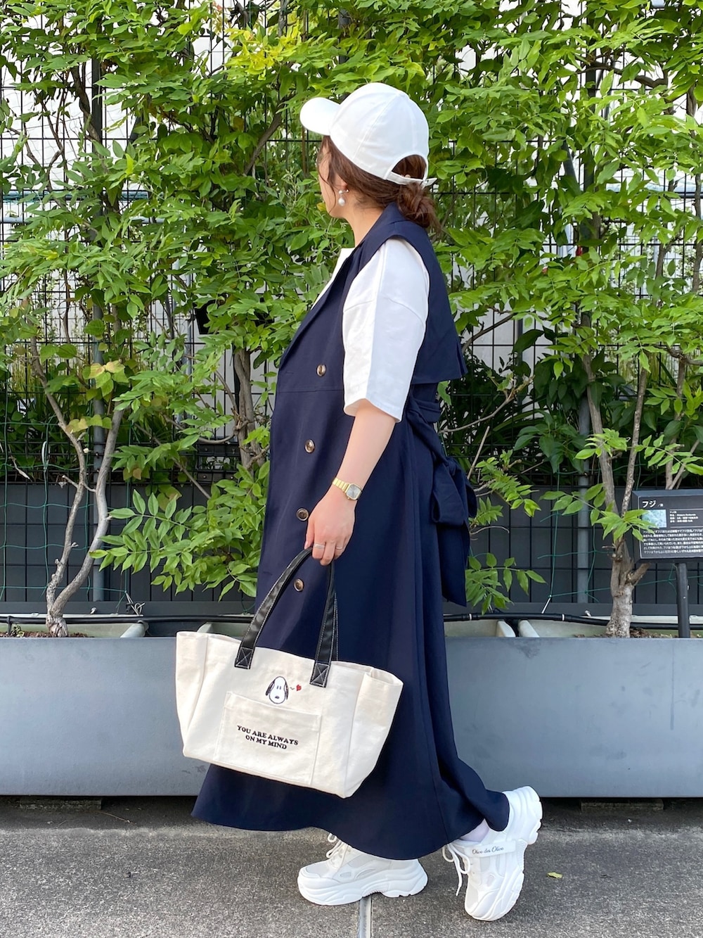 ブルー系のワンピース、ホワイト系のトートバッグ、ホワイト系のスニーカーを着用したレディースの春コーディネートの3枚目の写真