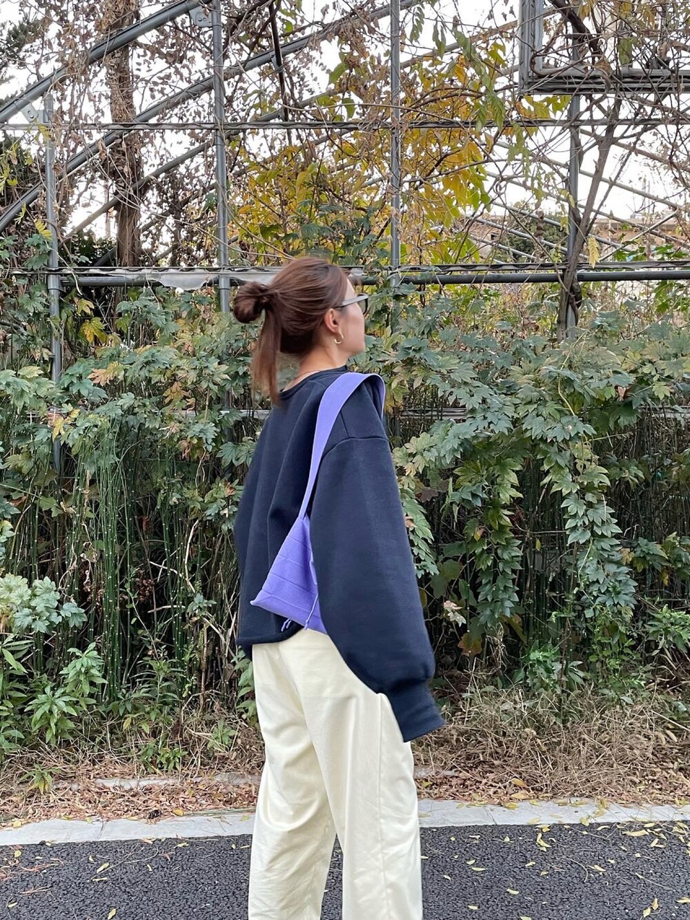 ブルー系のスウェット、イエロー系のパンツ、ブラック系のサンダルを着用したレディースの冬コーディネートの2枚目の写真