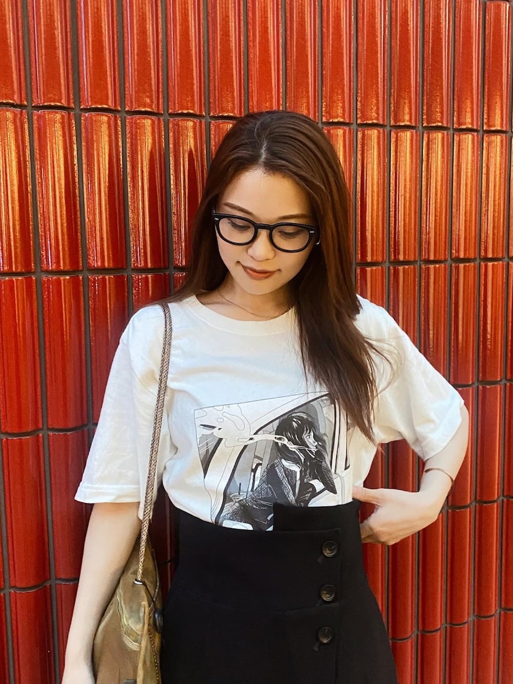ホワイト系のTシャツ/カットソー、ブラック系のスカート、ゴールド系のショルダーバッグを着用したレディースの秋コーディネートの2枚目の写真
