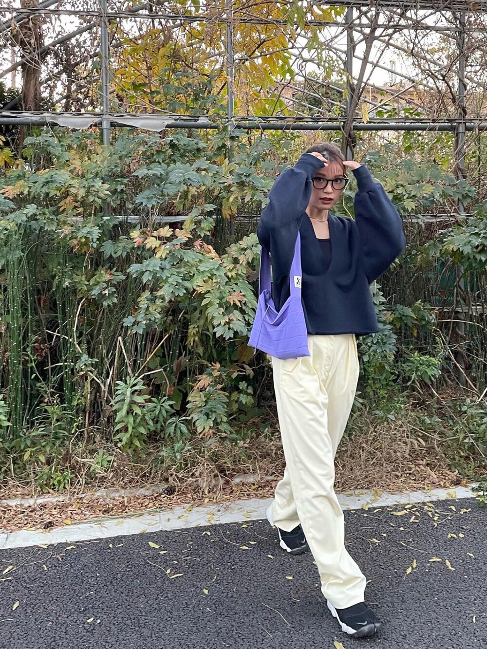 ブルー系のスウェット、イエロー系のパンツ、ブラック系のサンダルを着用したレディースの冬コーディネートの3枚目の写真