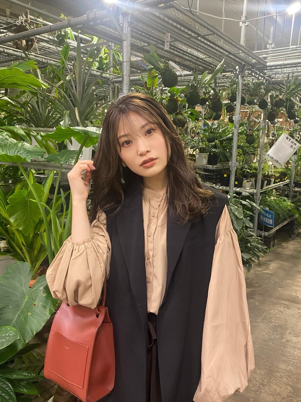 ベージュ系のシャツ/ブラウス、ブラック系のベスト、レッド系のショルダーバッグを着用したレディースの冬コーディネートの2枚目の写真