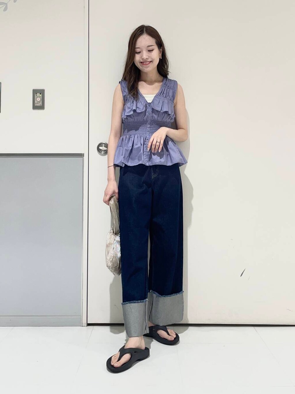 ホワイト系のキャミソール、ブラック系のサンダル、ゴールド系のハンドバッグを着用したレディースの夏コーディネートの3枚目の写真