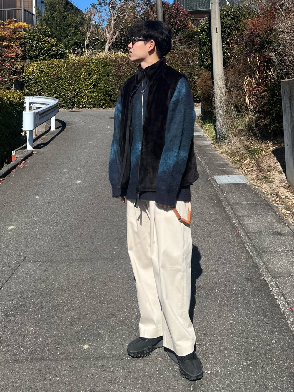 ブラック系のベスト、ホワイト系のその他パンツ、ブラック系のスニーカーを着用したメンズの冬コーディネートの3枚目の写真