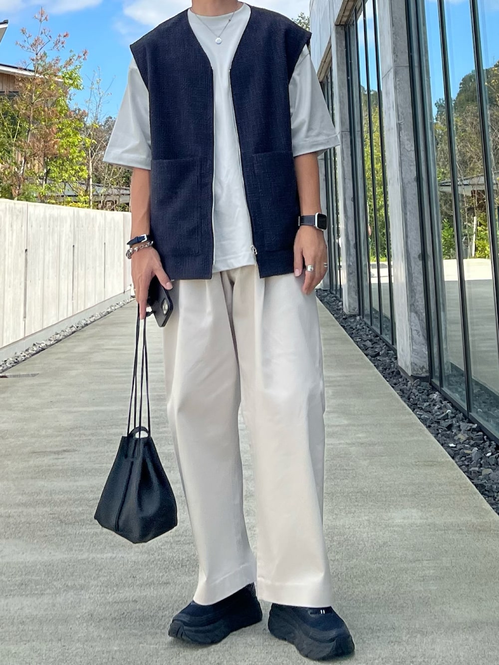 ブラック系のベスト、グレー系のTシャツ/カットソー、ホワイト系のその他パンツを着用したメンズの秋コーディネートの2枚目の写真