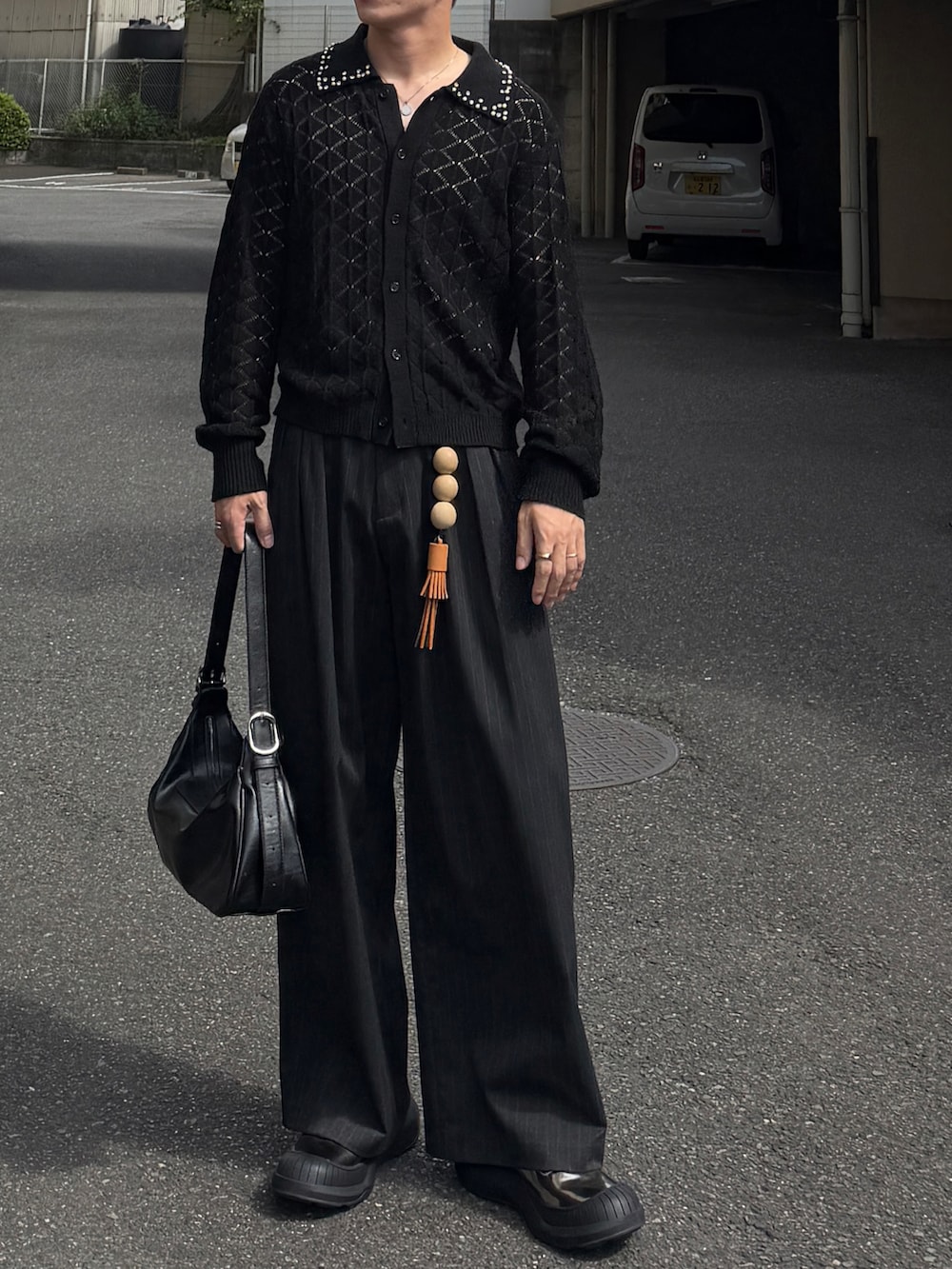 ブラック系のカーディガン/ボレロ、グレー系のスラックス、ブラック系のショルダーバッグを着用したメンズの秋コーディネートの3枚目の写真