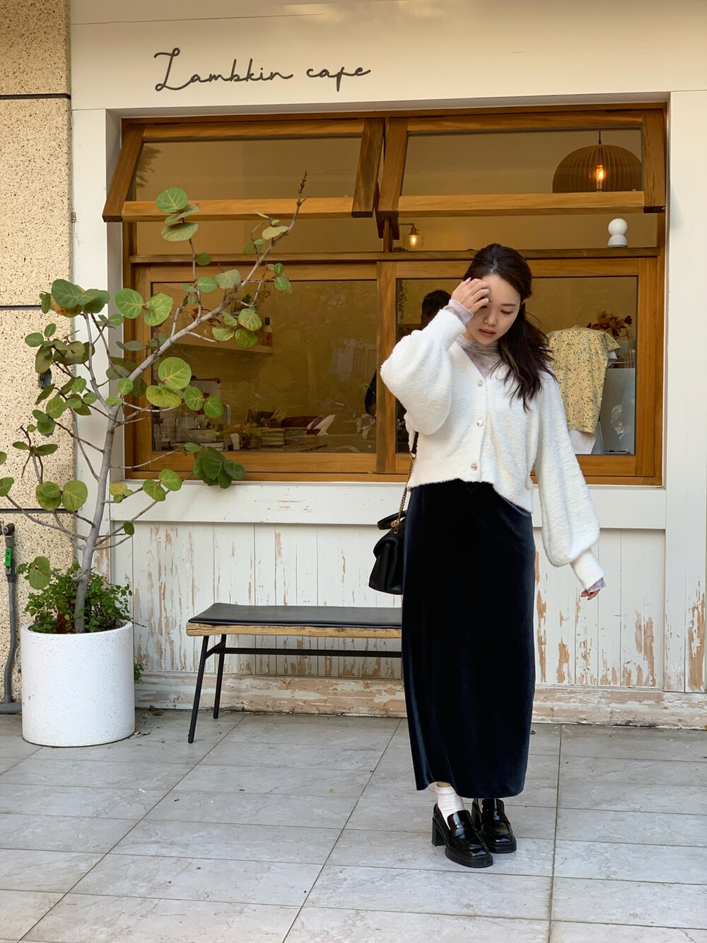 ブラック系のショルダーバッグ、ホワイト系のトップス、ブルー系のワンピース/ドレスを着用したレディースの冬コーディネートの3枚目の写真