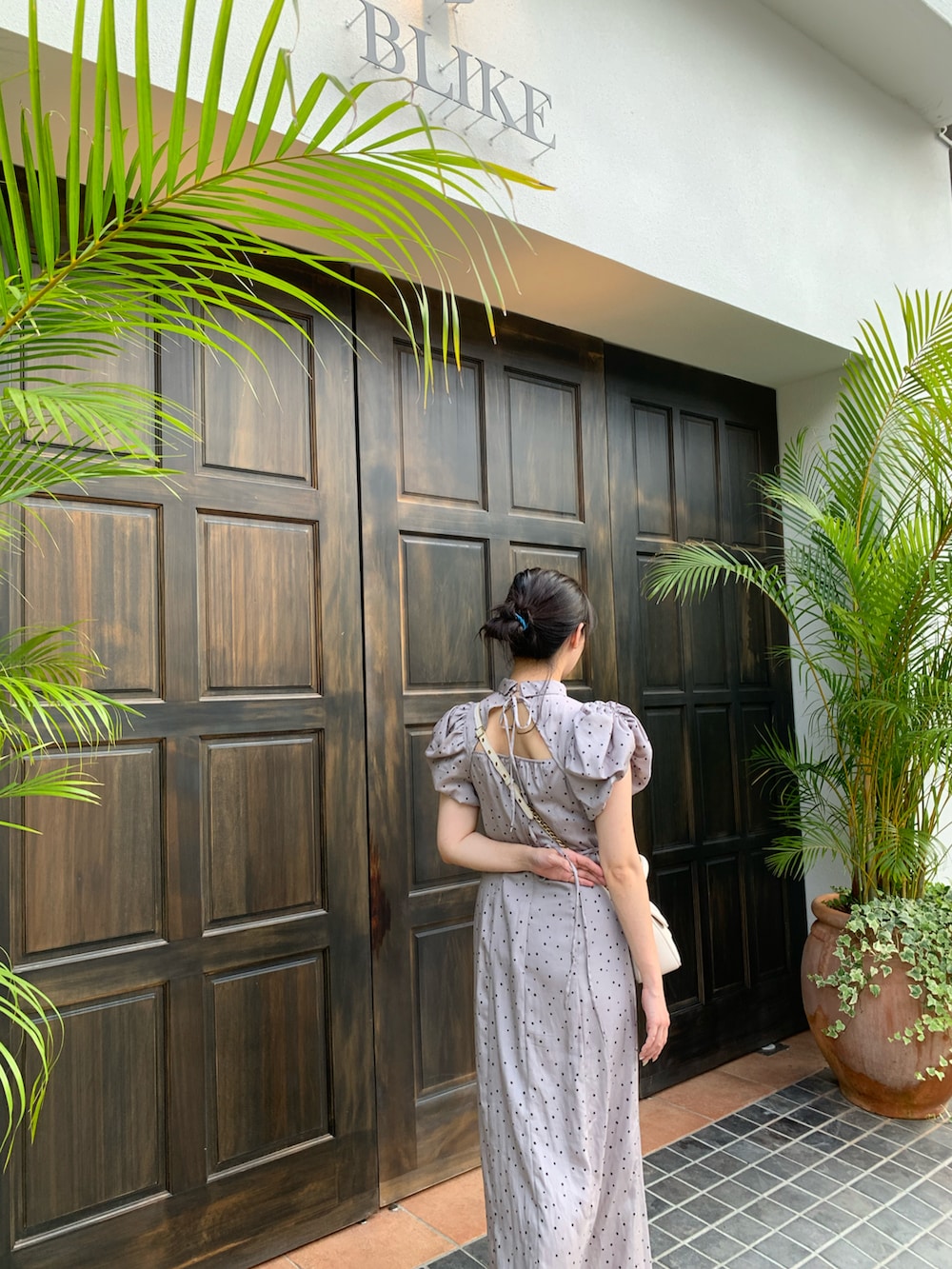 ブラック系のワンピース、ホワイト系のショルダーバッグを着用したレディースの春コーディネートの2枚目の写真