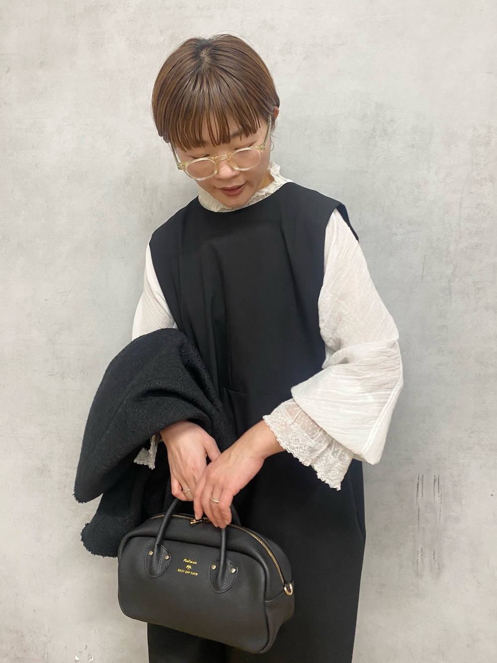 ホワイト系のシャツ/ブラウス、ブラック系のノーカラージャケット、ブラック系のハンドバッグを着用したレディースの冬コーディネートの6枚目の写真