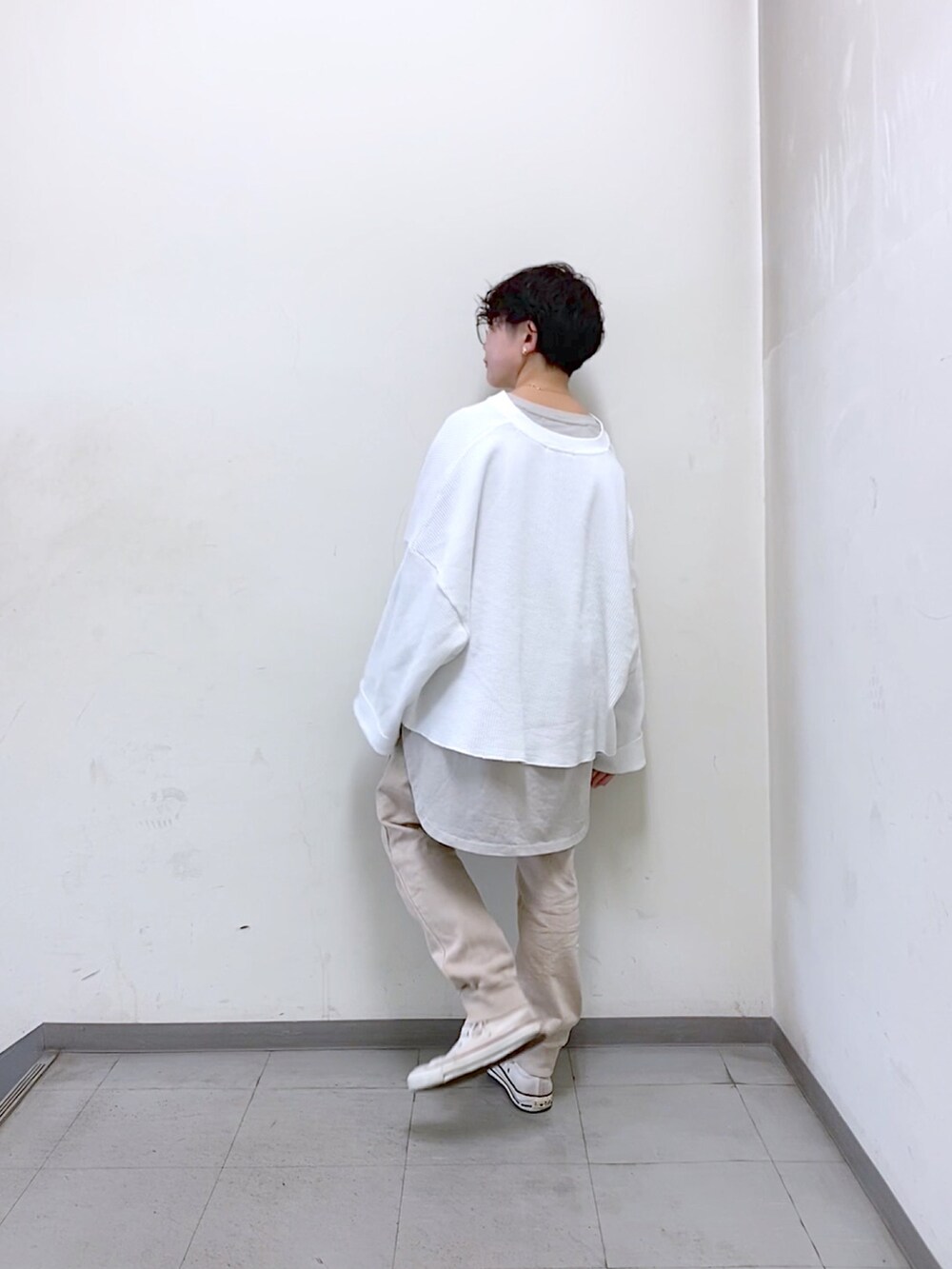 ホワイト系のスニーカー、ホワイト系のTシャツ/カットソー、ベージュ系のTシャツ/カットソーを着用したレディースの冬コーディネートの2枚目の写真