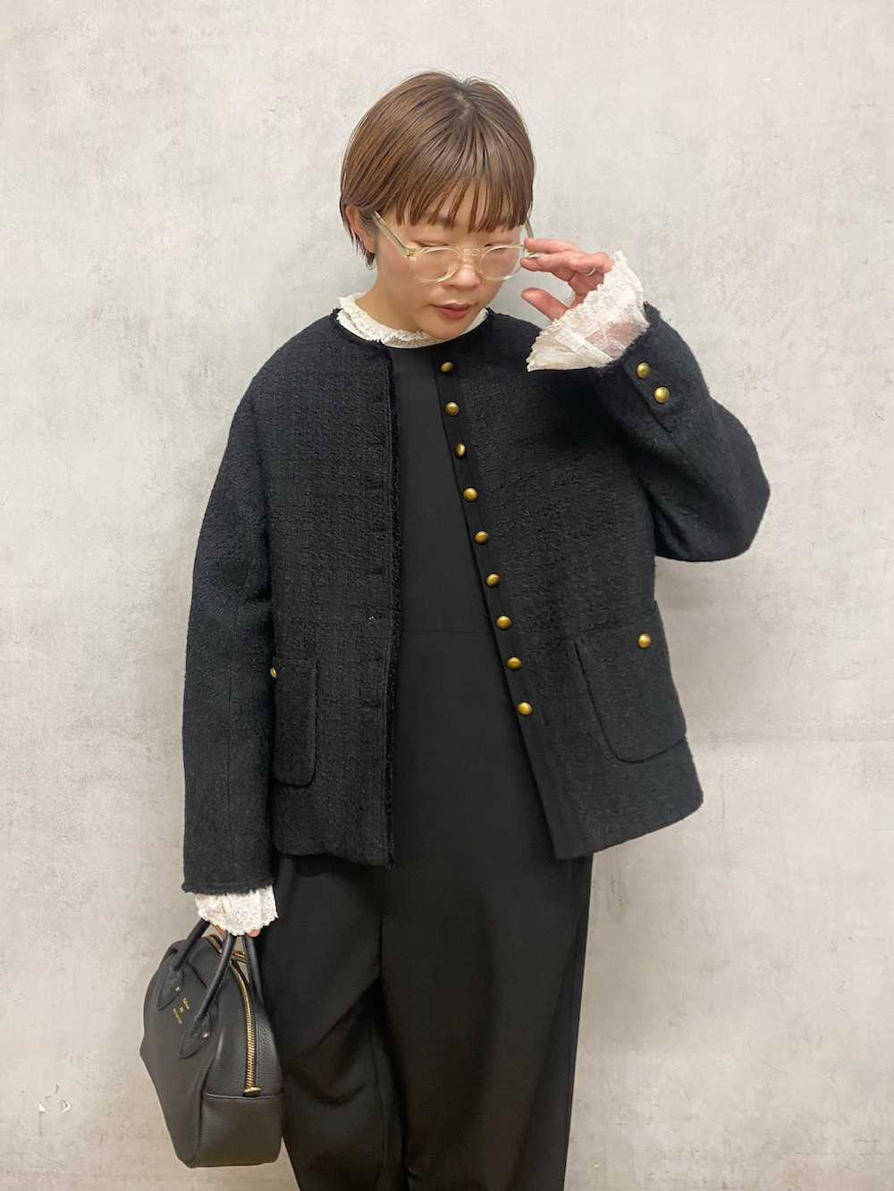 ホワイト系のシャツ/ブラウス、ブラック系のノーカラージャケット、ブラック系のハンドバッグを着用したレディースの冬コーディネートの3枚目の写真