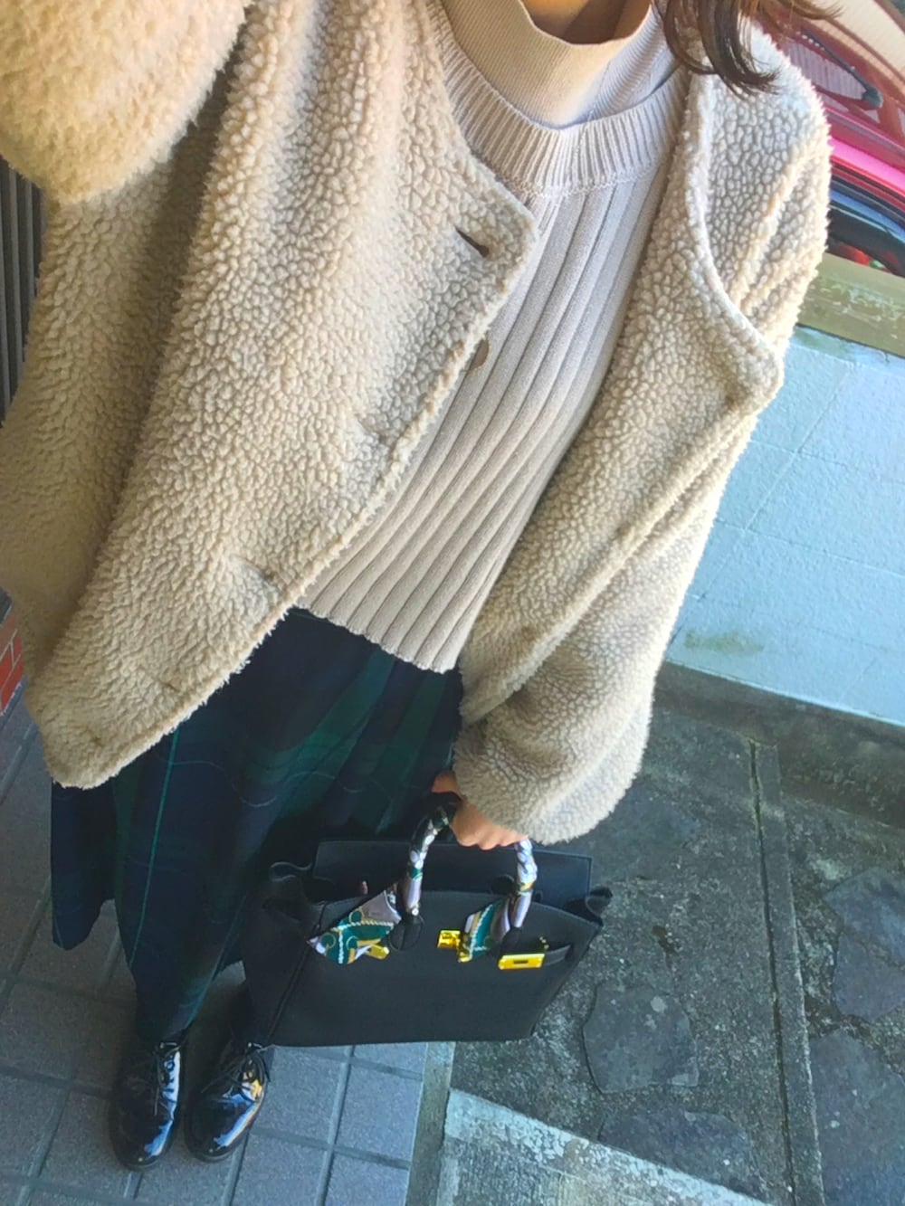 ベージュ系のジャケット/アウター、グレー系のニット/セーター、グリーン系のスカートを着用したレディースの冬コーディネートの2枚目の写真