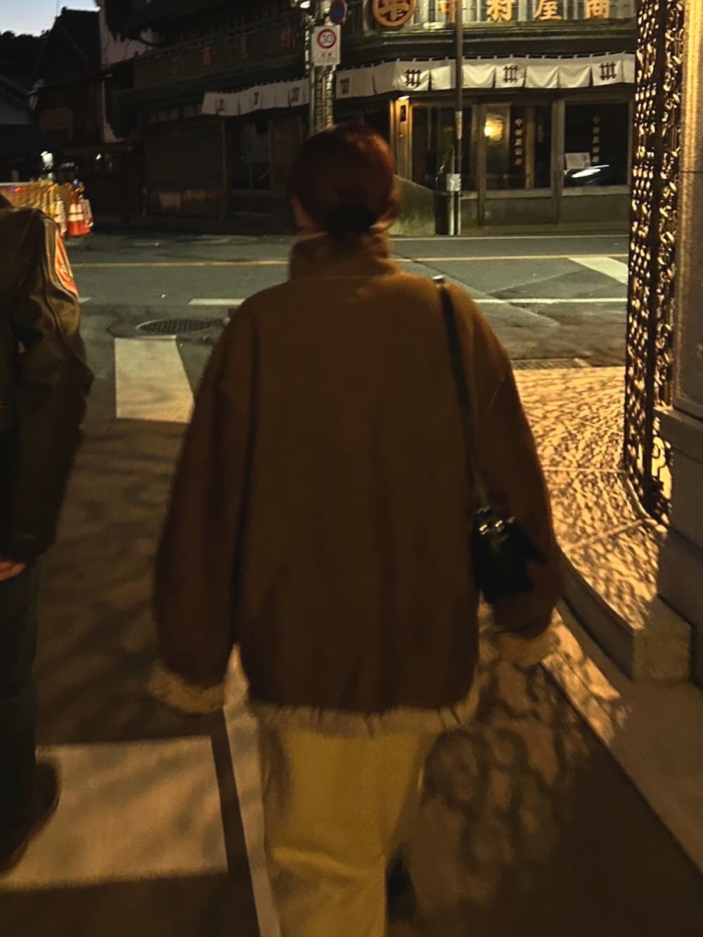 ブラウン系のムートンコート、ベージュ系のワンピース、ブラック系のローファーを着用したレディースの冬コーディネートの2枚目の写真