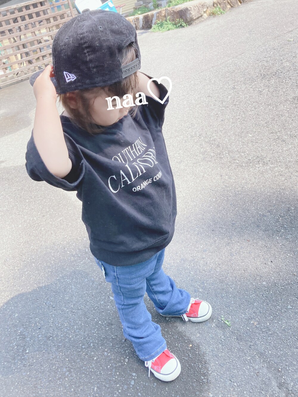 ブラック系のTシャツ/カットソー、ブルー系のデニムパンツ、レッド系のスニーカーを着用したキッズの秋コーディネートの2枚目の写真