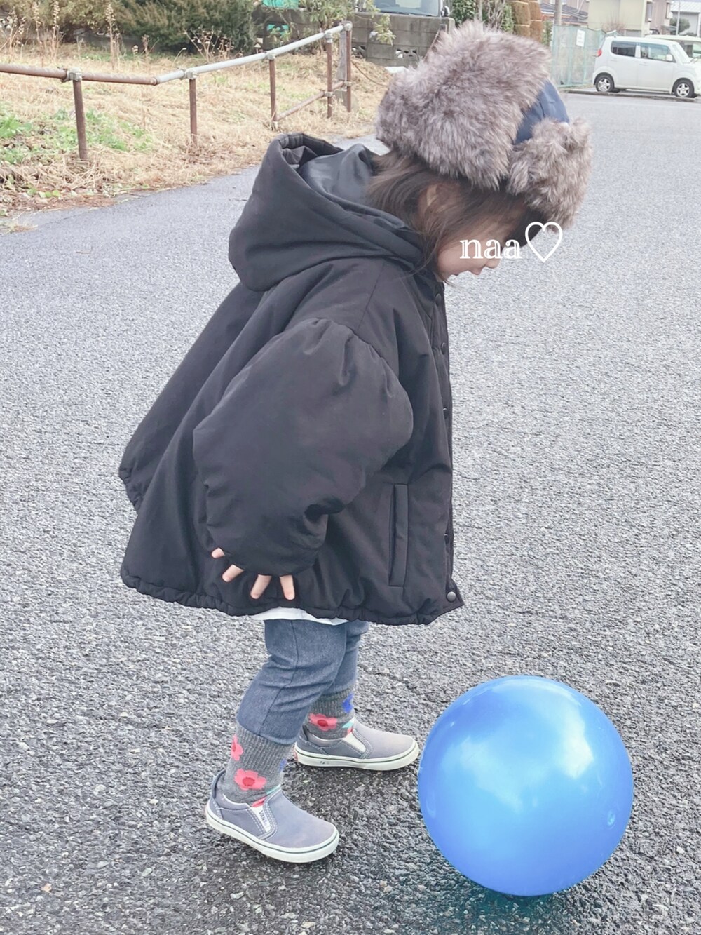 ブラック系のジャケット/アウター、ブルー系のスリッポン、ブルー系のキャップを着用したキッズの冬コーディネートの2枚目の写真