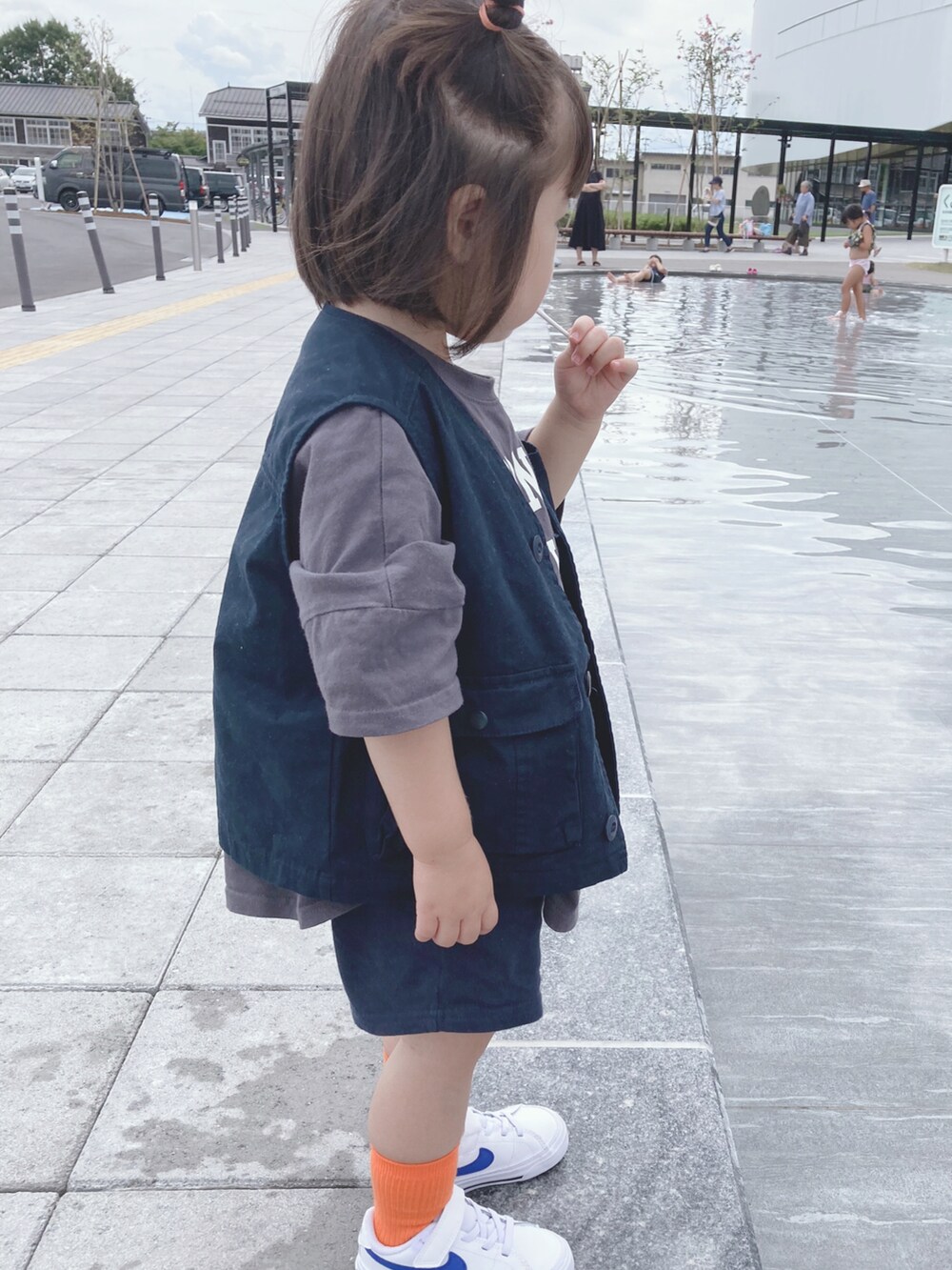 ブルー系のベスト、グレー系のTシャツ/カットソー、ホワイト系のスニーカーを着用したキッズの秋コーディネートの3枚目の写真